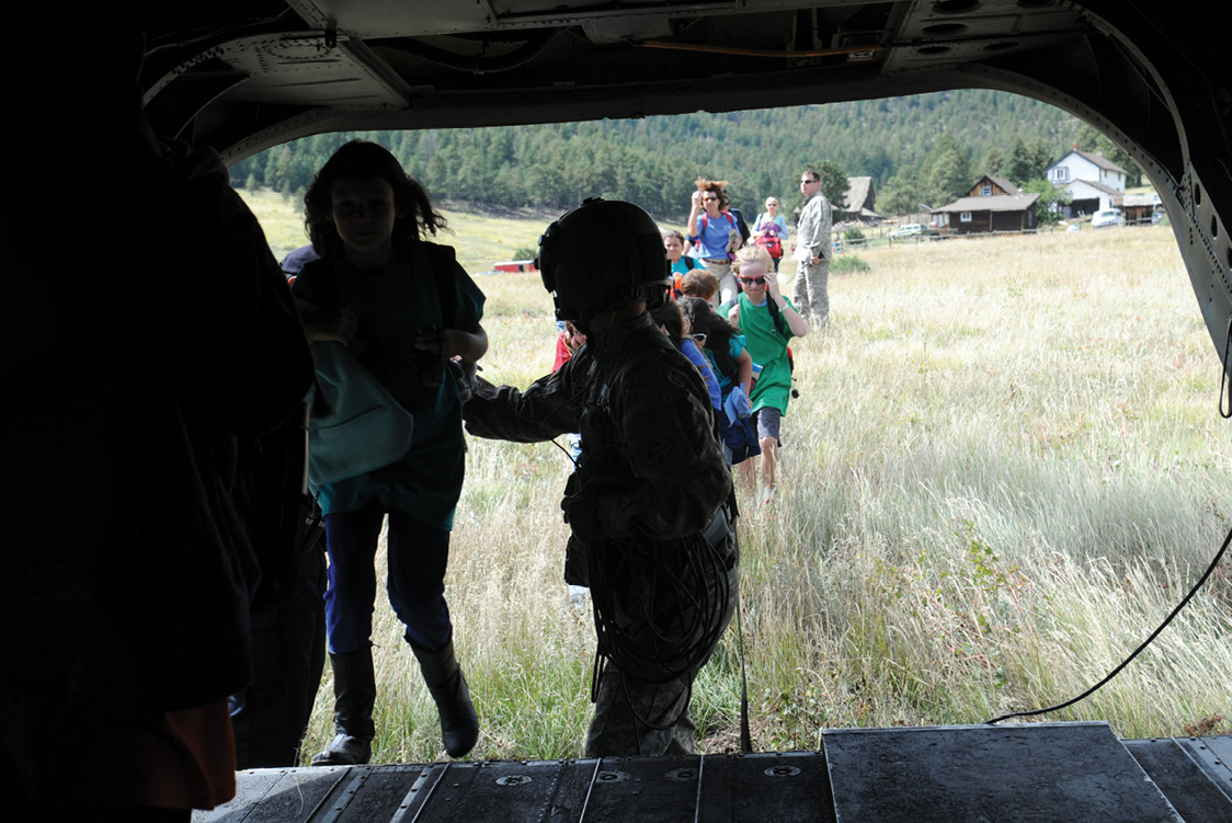 U.S. Soldiers with the 4th Combat Aviation Brigade, 4th Infantry Division, evacuate elementary school students in the wake of extreme flooding on 14 September
      2013 during emergency response efforts under IRA. (Credit: SSG Wallace Bonner)